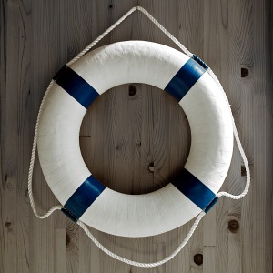 A round life preserver hanging on a wall.